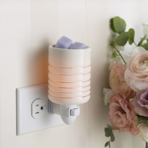 Serenity Pluggable Fragrance Warmer plugged into power point on wall near flowers